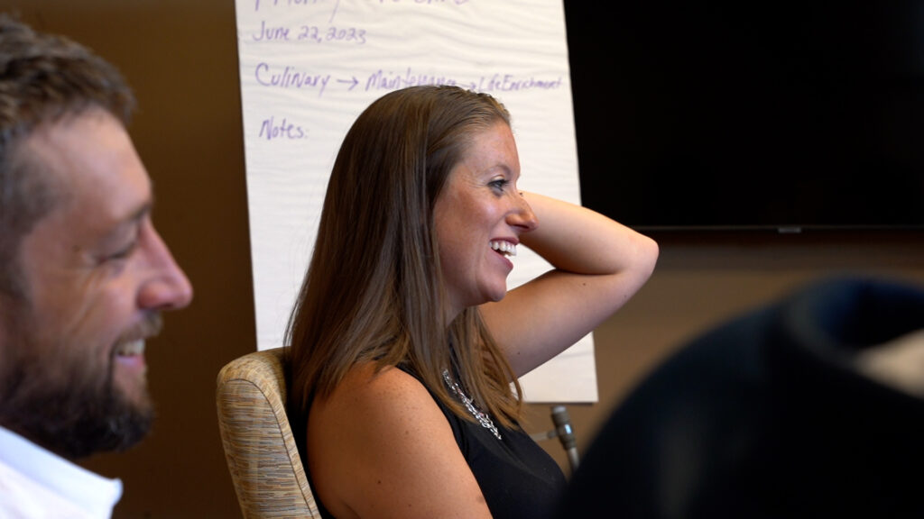 PLC_Champion.Still006-1024x576 woman smiling at a conference