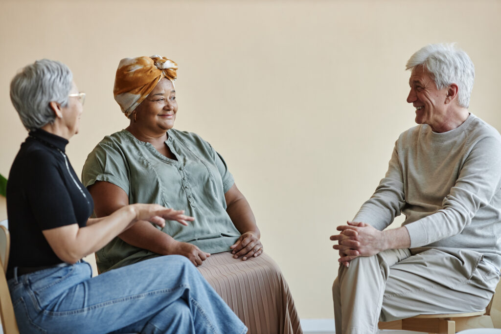 Senior people sitting in circle at mental health support group and sharing senior people sitting in circle at a support group