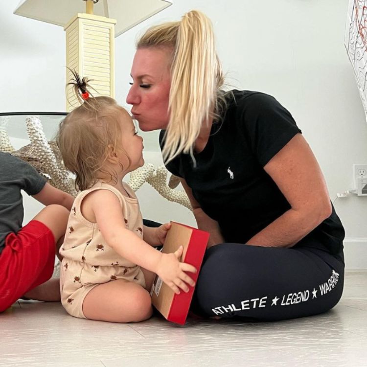 Sevy Petras kissing her young child on the forehead.