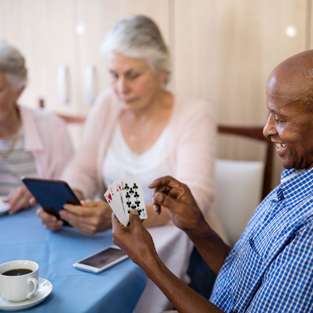 Seniors sitting at a table playing a card game